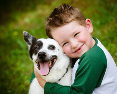 Young boy hugging small dog